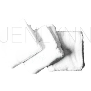 May include: Three white, fluffy, square-shaped pillows arranged on a white background.