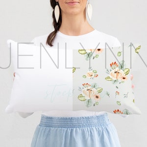 May include: A white pillow with the text "JENLYNN" printed on it. The pillow has a floral pattern on one side with peach, green, and orange flowers.