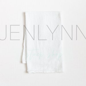 May include: White kitchen towel with the text "Jenlynn" and "Shop" written in a light blue cursive font.