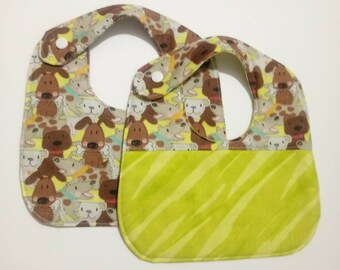 May include: Two baby bibs with a dog print pattern. One bib has a solid green underside with a striped pattern.