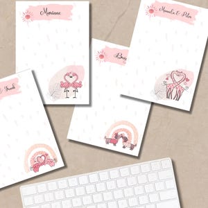 Könnte beinhalten: Eine Sammlung personalisierter Schreibwaren mit rosa Aquarellakzenten und skurrilen Illustrationen. Designs umfassen Flamingos, Giraffen und Dackel, mit Namen wie "Mariane" und "Manuela & Peter". Eine Tastatur ist im Vordergrund zu sehen.