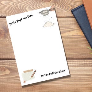 Könnte beinhalten: Ein weißer Notizblock mit dem deutschen Text "Hattu Kopf wie Sieb" oben, einer Illustration einer Hand, die ein Sieb hält und Pulver durchsiebt, sowie dem Text "muttu aufschreiben" unten, ergänzt durch eine kleine Notizblock- und Stiftgrafik.