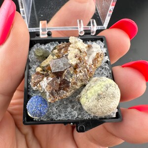 Puede incluir: Una taza de cerámica blanca con un asa negra y el texto "But First, Coffee" en negro, con una fuente de estilo manuscrito. La taza está sobre una superficie blanca.