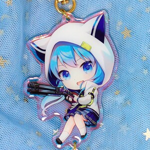 May include: A blue-haired anime character with a white hooded jacket and a gun, holding a keychain with a yellow axe and a blue star. The keychain is on a blue background with stars.