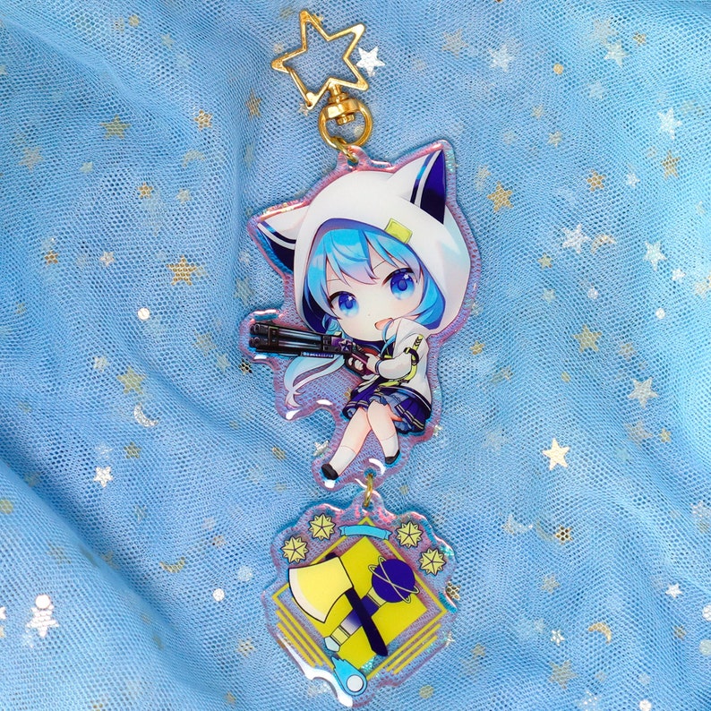 May include: A blue-haired anime character with a white hooded jacket and a gun, holding a keychain with a yellow axe and a blue star. The keychain is on a blue background with stars.