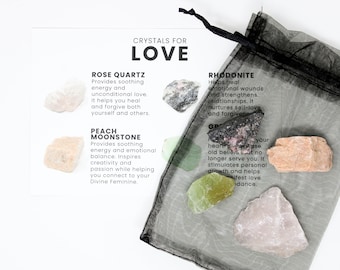 May include: A set of seven crystals in a black mesh bag with a white card that reads "Crystals for Love" and lists the names and properties of each crystal: Rose Quartz, Peach Moonstone, Rhodonite, Green Aventurine, Clear Quartz, Selenite, and Amethyst.