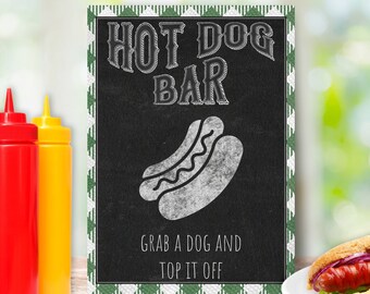 Puede incluir: Un letrero rectangular con fondo de pizarra negra y borde con patrón verde y blanco. El texto dice HOT DOG BAR y GRAB A DOG AND TOP IT OFF. Una ilustración en tiza blanca de un perrito caliente está centrada entre las líneas de texto.