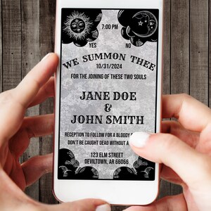 May include: A digital wedding invitation displayed on a smartphone screen featuring a grey textured background with black celestial graphics of a sun and moon. The text reads: WE SUMMON THEE, 10/31/2024, FOR THE JOINING OF THESE TWO SOULS, JANE DOE & JOHN SMITH.