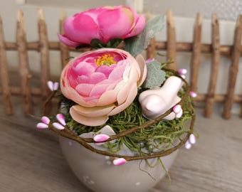 Decorazione da tavola: piccolo uovo in ceramica grigia decorato con fiori, ranuncoli e un uccellino.