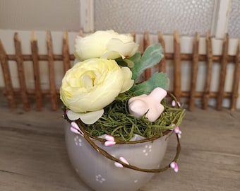 Decorazione da tavola: piccolo uovo in ceramica grigia decorato con fiori, ranuncoli e un uccellino.