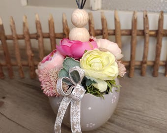 Decorazione da tavola: piccolo uovo in ceramica grigia decorato con fiori, ranuncoli e un coniglio.