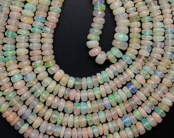 May include: Strands of faceted opal beads in various sizes and shapes. The opals display a range of colors, including white, pink, blue, and green, with iridescent flashes. The beads are strung together, creating a flowing, organic pattern.