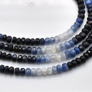 May include: A strand of blue sapphire beads in various shades of blue, from light to dark, with black sapphire beads interspersed throughout.