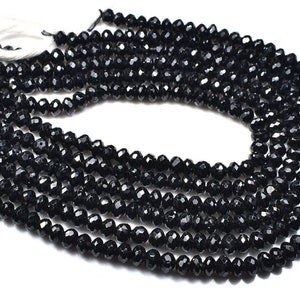 Puede incluir: Una hebra de cuentas de piedras preciosas facetadas negras. Las cuentas son redondas y tienen un acabado brillante y pulido.