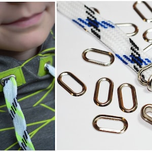 May include: Silver metal grommets with a 15mm inner diameter. The grommets are shown on a white and blue striped cord. The grommets are used for attaching cords to fabric.