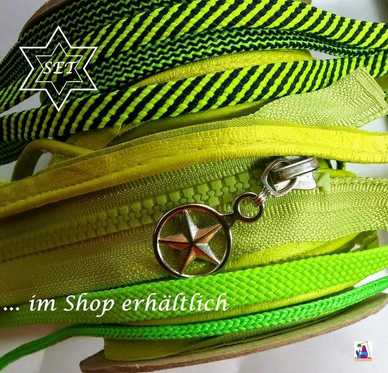 May include: A coiled lime green zipper featuring a metallic silver star-shaped pull tab. The zipper is layered with a black and lime green striped fabric trim. The text SET is visible in a white star outline, and the text im Shop erh&auml;ltlich is present.