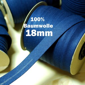 Könnte beinhalten: Nahaufnahme einer Spule mit dunkelblauem Baumwollband, 18 mm breit, mit der Aufschrift "100% Baumwolle 18mm".