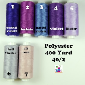 Könnte beinhalten: Sieben Spulen Polyestergarn in verschiedenen Farbtönen von Lila, Rosa und Blau. Die Spulen sind mit den Nummern 1 bis 7 und Farbnamen in Deutsch beschriftet. Der Text "Polyester 400 Yard 40/2" ist auf weißem Hintergrund gedruckt.