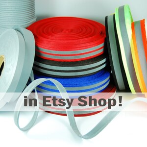 May include: Assortment of reflective ribbon rolls in various colors, including red, blue, gray, orange, yellow, and green. The ribbon is available in an Etsy shop.