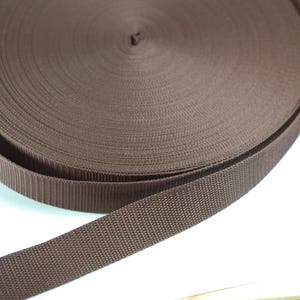 Hochwertiges 30 mm Gurtband in Dunkelbraun. Strapazierfähiges Gurtband für Taschen, Rucksäcke, Schultergurte, Hundeleinen, Gürtel sowie kreative Näh- und DIY-Projekte. Robustes, fein gewebtes Band für langlebige und professionelle Handarbeiten.