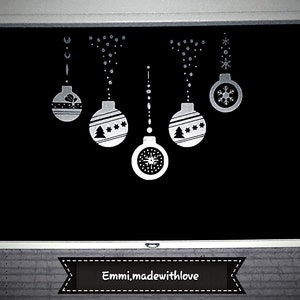 Puede incluir: Una superficie negra decorada con adornos navide&ntilde;os blancos. Los adornos incluyen copos de nieve, estrellas y un dise&ntilde;o de &aacute;rbol de Navidad. El texto "Emmi.madewithlove" se muestra en una pancarta en la parte inferior.