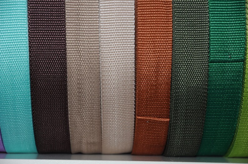 Mehrere Rollen hochwertiges 30 mm Gurtband in Grün, Dunkelblau, Weiß, Rosa, Hellblau, Braun, Beige, Lila, Pink und Grau. Strapazierfähiges Gurtband für Taschen, Rucksäcke, Schultergurte, Hundeleinen, Gürtel sowie kreative Näh- und DIY-Projekte. Robustes, fein gewebtes Band für langlebige und professionelle Handarbeiten.