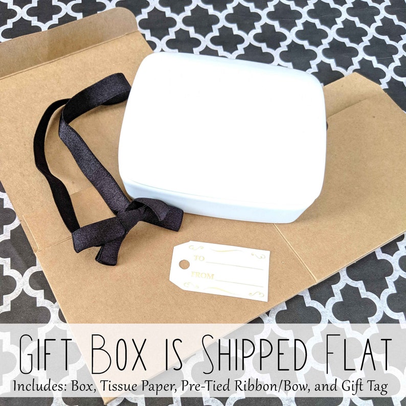 May include: A white gift box with a black ribbon and a gift tag that says "TO FROM". The box is shipped flat and includes tissue paper, a pre-tied ribbon, and a gift tag.