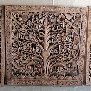 May include: Three intricately carved wooden panels featuring a floral design. The center panel depicts a large tree with intricate branches and leaves. The panels are a rich brown color and have a rustic, antique look.
