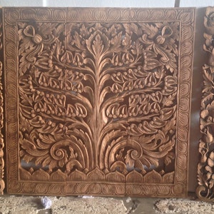May include: Three intricately carved wooden panels with floral and tree designs. The panels are made of light brown wood and feature raised details. The center panel depicts a tree with branches and leaves, while the side panels feature floral motifs.