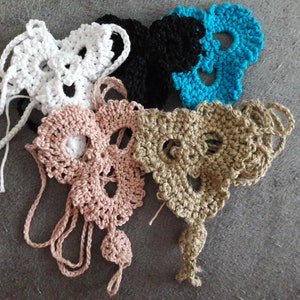 May include: Four crocheted skull shapes in white, black, light brown, and turquoise.