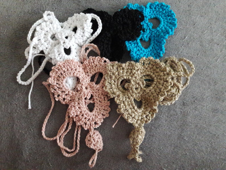 May include: Four crocheted skull shapes in white, black, light brown, and turquoise.