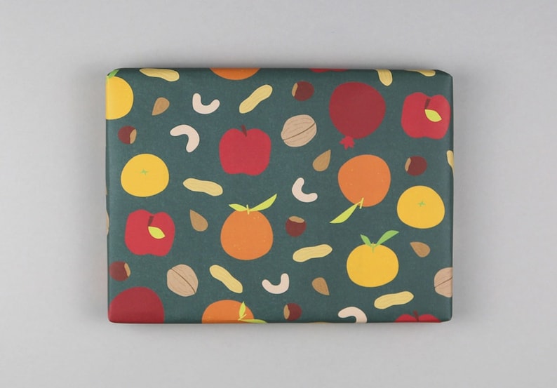 May include: Green wrapping paper with a repeating pattern of oranges, apples, peanuts, cashews, and walnuts.
