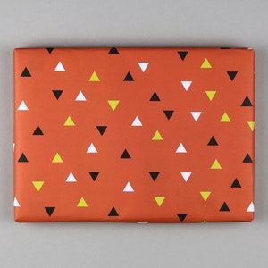 May include: Orange wrapping paper with a repeating pattern of black, white, and yellow triangles.