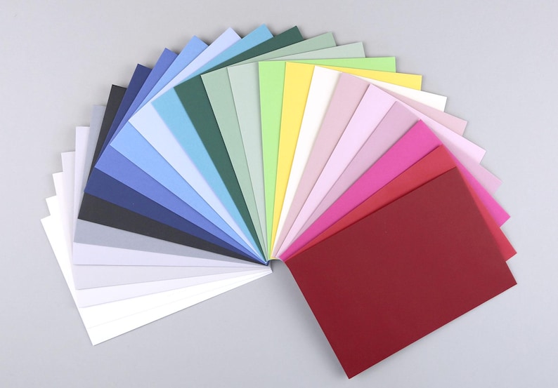 Op de afbeelding: Een waaier van 20 verschillende gekleurde vellen karton. De kleuren vari&euml;ren van donkerblauw tot rood.