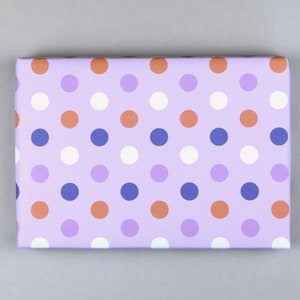 May include: Purple wrapping paper with a polka dot pattern in white, orange, and blue.