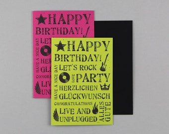 May include: Two birthday cards with a rock and roll theme. The top card is pink with the text "HAPPY BIRTHDAY!" The bottom card is green with the text "HAPPY BIRTHDAY! LET'S ROCK PARTY" and other text in English and German.