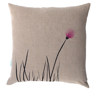 Pode incluir: Almofada quadrada de linho bege com um desenho de grama preta e uma flor rosa. O design é minimalista e adequado para decoração de casa. A cor neutra da almofada a torna versátil para vários estilos de interiores.