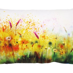 May include: A watercolor pillow cover featuring a field of wildflowers in shades of yellow, orange, pink, and green. The background is a soft white with a subtle watercolor effect.