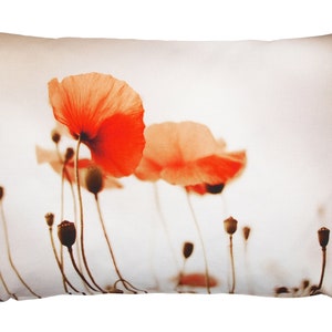 May include: A white pillow with a printed image of red poppies on a white background.
