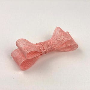 May include: A set of three ceramic mugs with a speckled, matte finish. The mugs are in shades of cream, light gray, and dark gray. Each mug has a simple, minimalist design and a rounded handle.