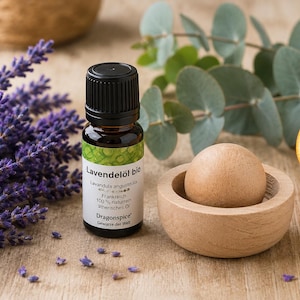 Könnte beinhalten: Eine kleine Braunglasflasche mit biologischem Lavendelöl, schwarzem Verschluss und weißem Etikett mit der Aufschrift Lavendelöl bio, Lavandula angustifolia, Frankreich, 100% naturrein ätherisches Öl und Dragonspice Gewürze der Welt.