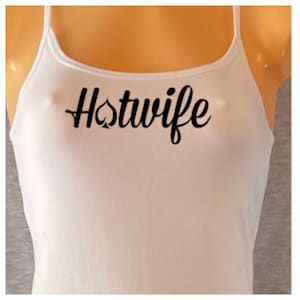 May include: White tank top with the text "Hotwife" in black cursive lettering with a spade symbol.