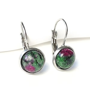 Könnte beinhalten: Ein Paar silberne Ohrringe mit grünen und rosafarbenen Edelstein-Cabochons. Die Ohrringe haben einen einfachen Hakenverschluss.