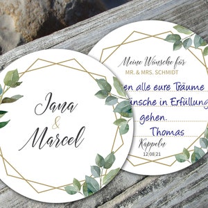 Könnte beinhalten: Zwei weiße, runde Hochzeitsuntersetzer mit goldenen geometrischen Rändern und Aquarellgrün. Ein Untersetzer trägt die Aufschrift "Jana & Marcel". Der andere hat deutschen Text und das Datum "12 08 21".