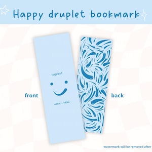 Peut inclure: Deux marque-pages bleu clair. Le marque-page avant présente un visage souriant et les mots "happiest when I read". Le marque-page arrière présente un motif de gouttelettes bleues. Le texte "Happy druplet bookmark" est en haut.