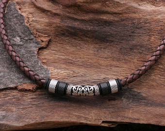 Elegante leren herenketting met roestvrijstalen kralen en een versierd metalen gedeelte, lengte 45 cm.