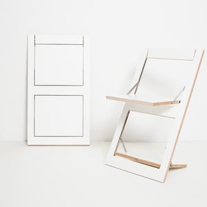 May include: A white folding chair and table set. The chair and table are made of wood and have a simple, modern design.