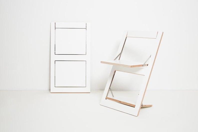 May include: A white folding chair and table set. The chair and table are made of wood and have a simple, modern design.