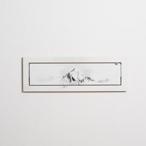 以下が含まれることがあります： 白い額縁に入った、山脈の白黒の墨絵です。