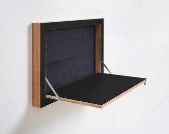 May include: A black fold-down desk with a wooden frame, mounted to a wall. The desk is open and the surface is black.
